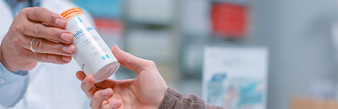 Pharmacist handing a customer their perscription.